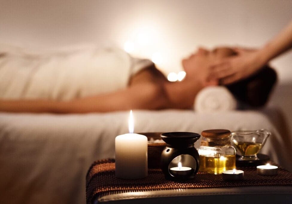Aroma Spa. Girl Enjoying Massage In Luxury Spa With Candles On Foreground
